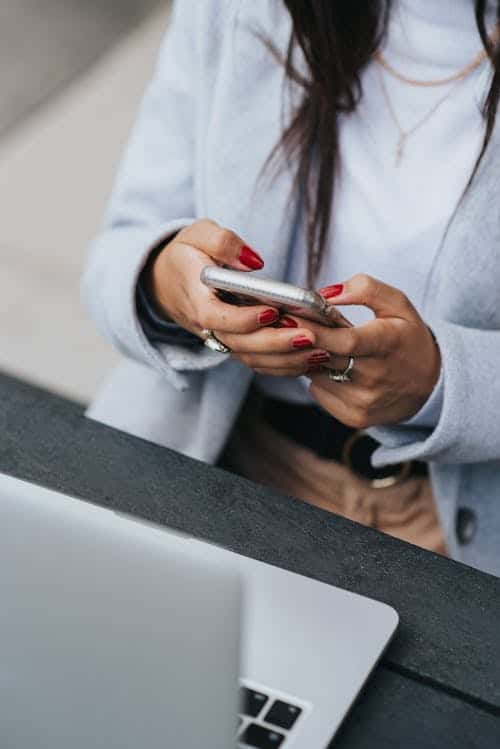 9-5 Grind vs. Self-employment lady looking on the phone with laptop